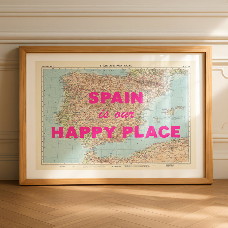 Framed map of Spain with 'Spain is our happy place' text on a wooden floor.