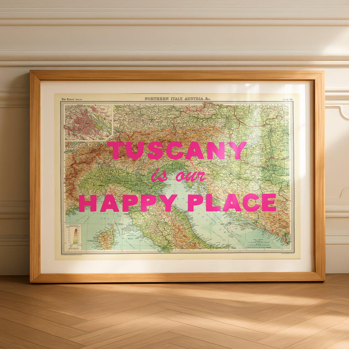 Framed map of Tuscany with 'Tuscany is our happy place' text on a wooden floor.