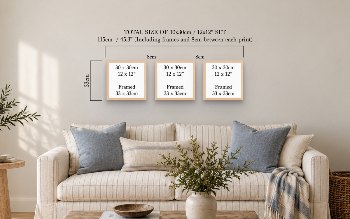A staged living room scene with a cream sofa, blue-gray pillows, and a vase on a table, showing a wall graphic that explains the size of a set of three framed art prints. The graphic reads: TOTAL SIZE OF 30x30cm / 12x12" SET, 115cm / 45.