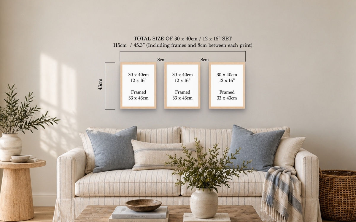 Three framed art prints displayed on a beige wall above a cream sofa in a styled living room. White text at the top shows the dimensions of the set: three 30 x 40 cm prints with 8 cm spacing, labeled as a 115 cm / 45.