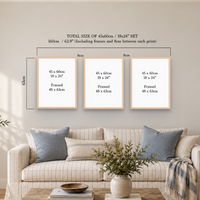 Three framed art prints displayed on a beige wall above a sofa, with overlaid dimension labels showing the total size of a 45x60cm / 18x24" set. The scene is styled as a living room with a striped sofa, pillows, and a vase with greenery.