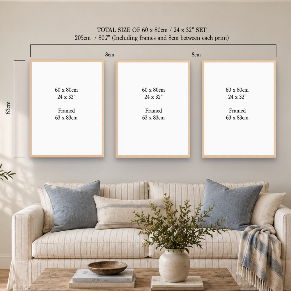 Three framed wall art prints displayed above a beige sofa in a styled living room. The image includes dimension labels and text stating the total size of the set is 60 x 80 cm / 24 x 32" set, 205 cm including frames and spacing, with each print labeled 60 x 80 cm / 24 x 32" and framed 63 x 83 cm.