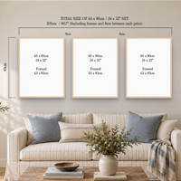 Three framed wall art prints displayed above a beige sofa in a styled living room. The image includes dimension labels and text stating the total size of the set is 60 x 80 cm / 24 x 32" set, 205 cm including frames and spacing, with each print labeled 60 x 80 cm / 24 x 32" and framed 63 x 83 cm.