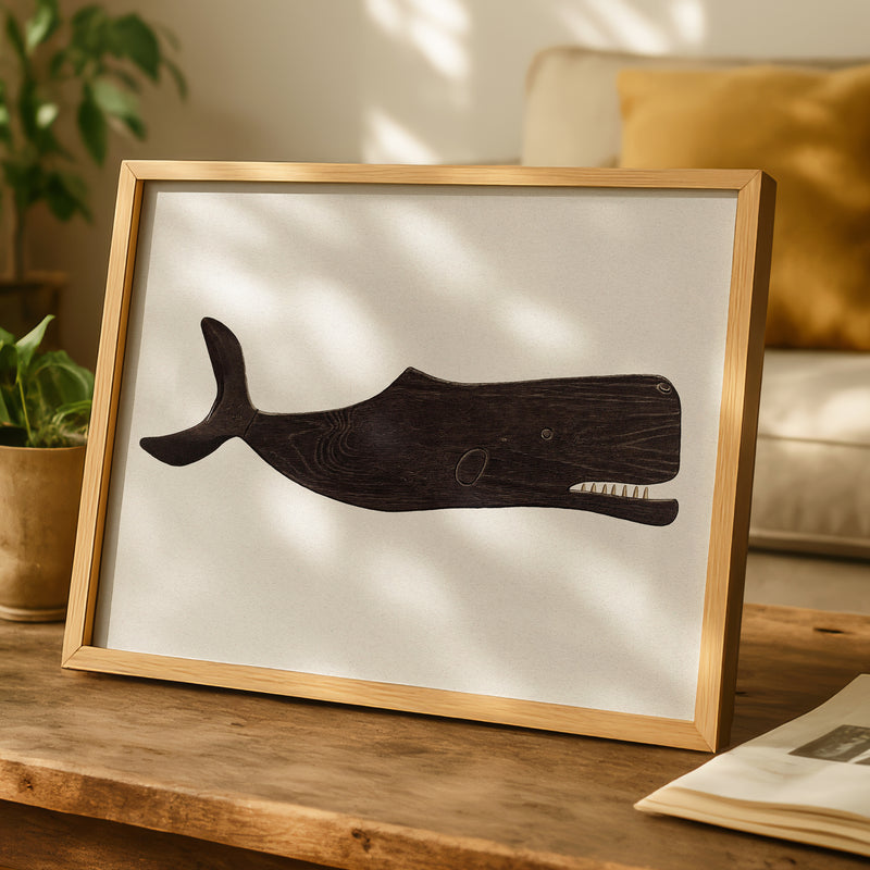 Framed illustration of a whale on a wooden table with a cozy indoor setting.