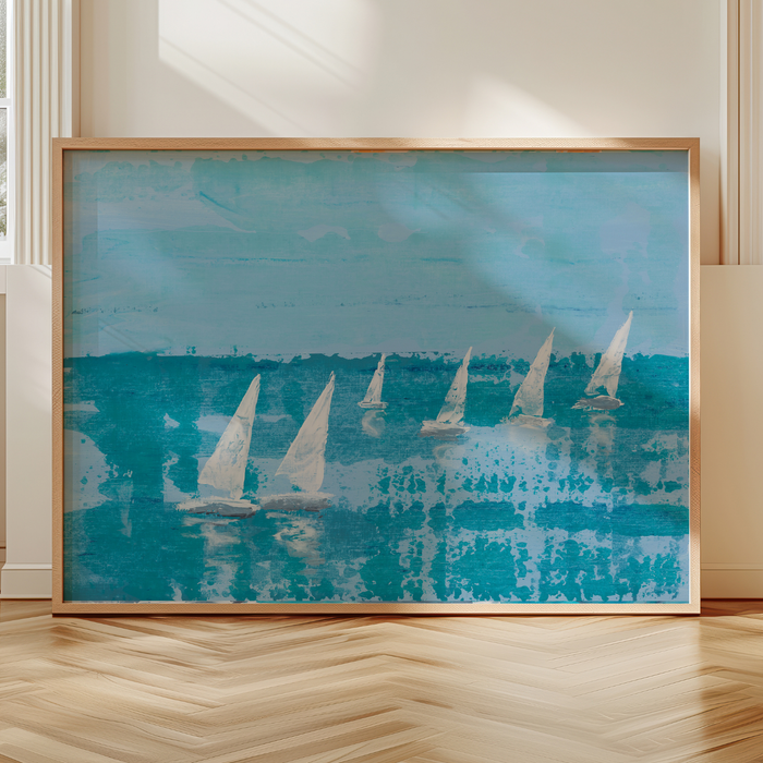Framed artwork of sailboats on a blue background in a room with wooden flooring.