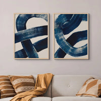 set of two wall art prints of knots in natural frames above a sofa