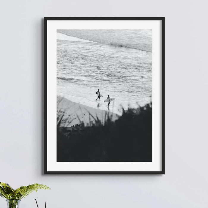 B & W photograph of two surfers on beach in a black frame above a sideboard - beach house art