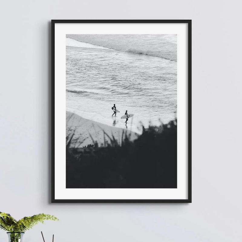 B & W photograph of two surfers on beach in a black frame above a sideboard - beach house art