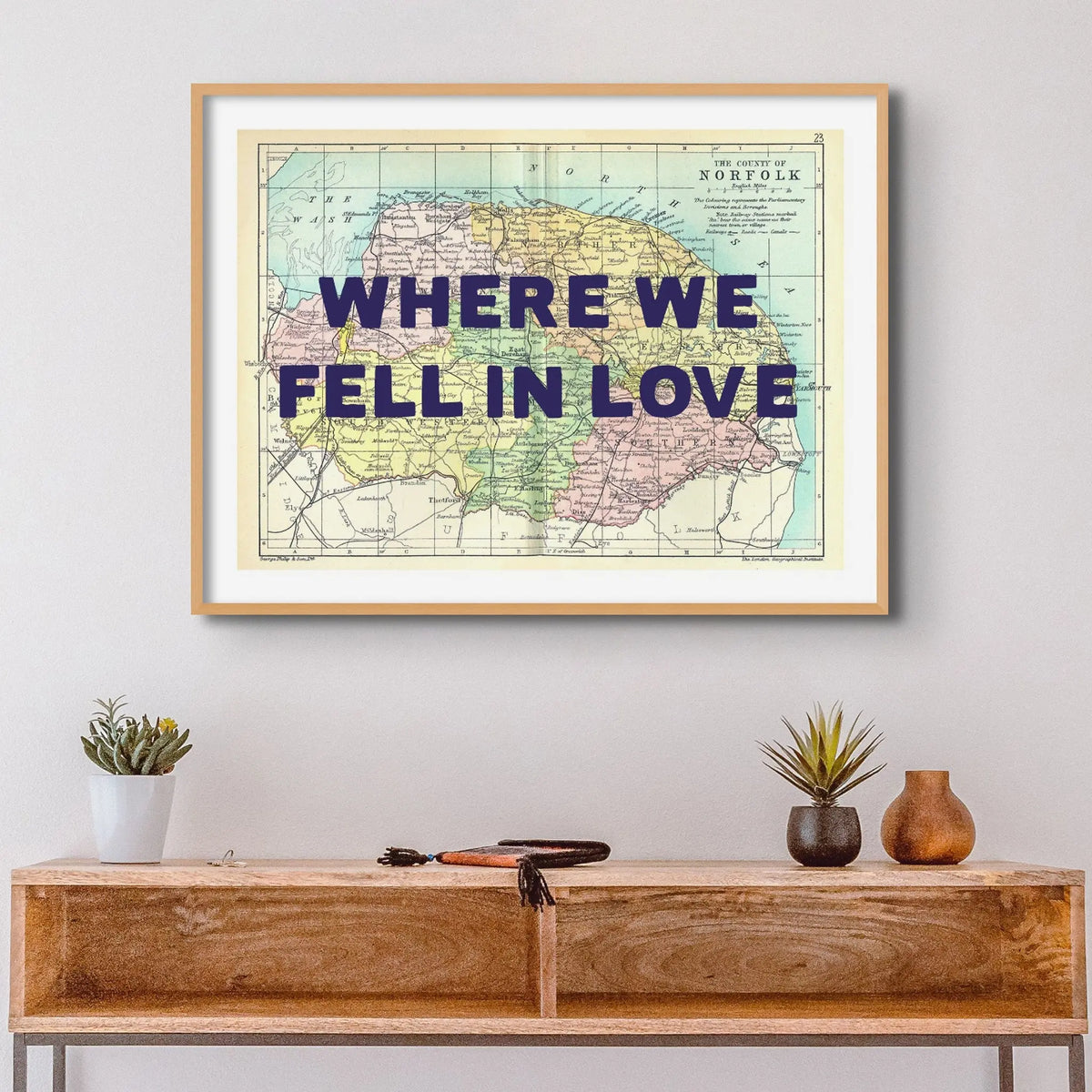 Coastal wall art featuring a personalised vintage map print of Norfolk with pink font - Framed wall art