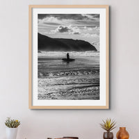 black & white photograph of a surfer on the beach framed above a side table- beach house art