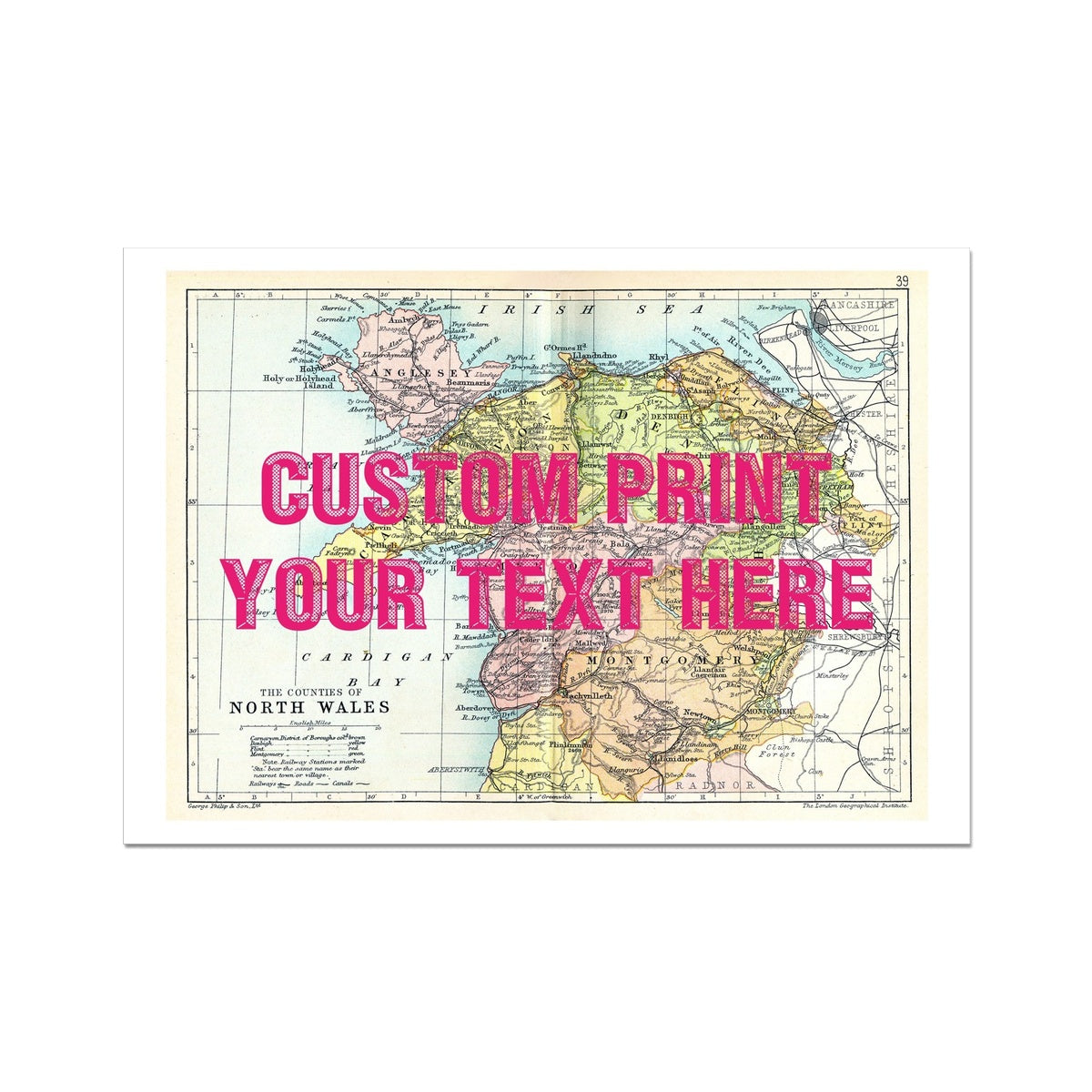 A custom map print of North Wales with a pink vintage font placeholder text saying 'CUSTOM PRINT YOUR TEXT HERE' on top.